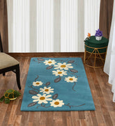 Modern artisan rug featuring daisies with teal background